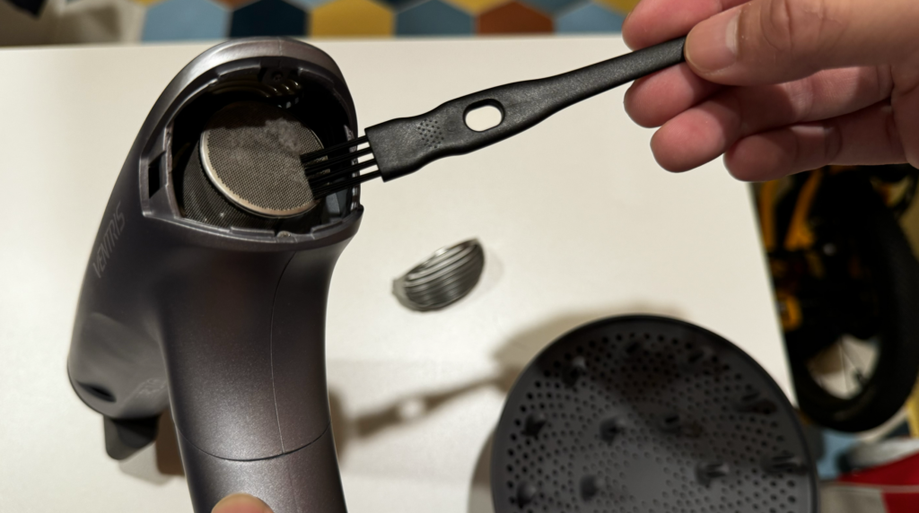 Next, you can use the included brush to remove any dust or hair, keeping the back cover clean. This helps the hair dryer maintain peak performance and reduces the chance of inhaling dust through your nostrils while using it.